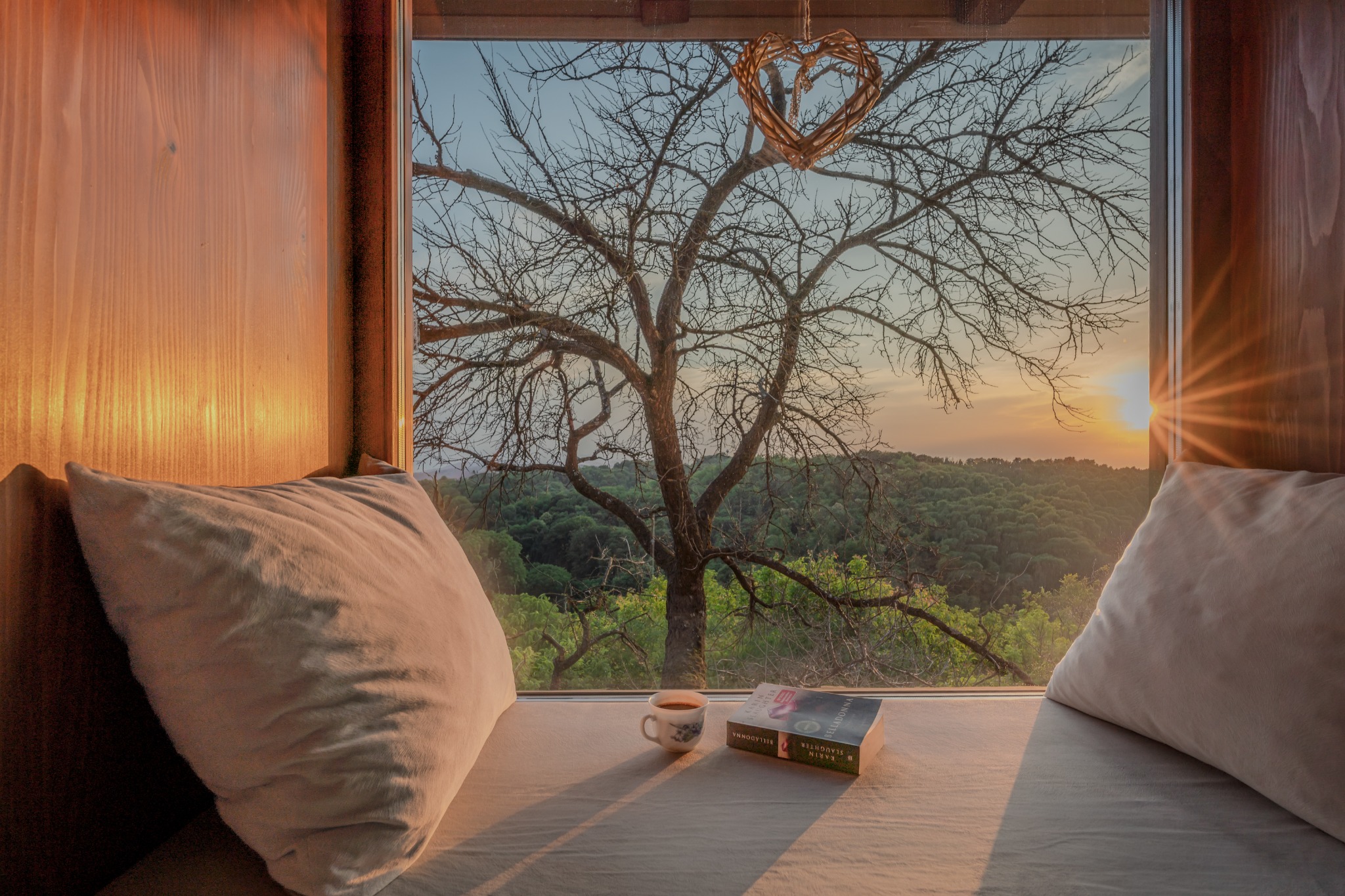 Two windows inside Vila Ivka looking out over the surrounding hills at sunset